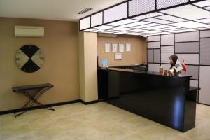 a woman standing at a counter in a room at Airport Residence in Istanbul