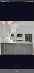 a large kitchen with white cabinets and appliances at Elegant and Comfortable, nice house in Orlando