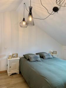 a bedroom with a large bed with two pillows at La petite maison in Neuvic