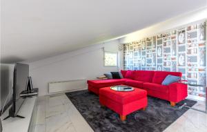 a living room with a red couch and a red stool at Apartment Krilo Jesenice 24 in Jesenice