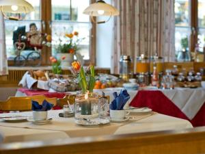 a table with flowers in a dining room at Gasthof Metzgerei Stöberl in Lam