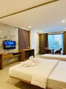 马尼帕尔Richmond Inn and Suites的一间配有床和平板电视的酒店房间