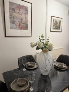 a table with plates and a vase with flowers on it at Gray Bridge Room in Northampton