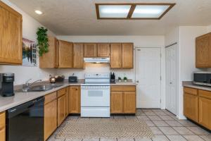 a kitchen with wooden cabinets and a white stove top oven at Cozy Three Bedroom Home in Pocatello