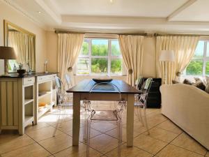 una sala de estar con una mesa y un sofá en 'Goldwater on Beach' - 3 Bedroom Beachfront with Balcony & BBQ - Sleeps 6, en Gordonʼs Bay