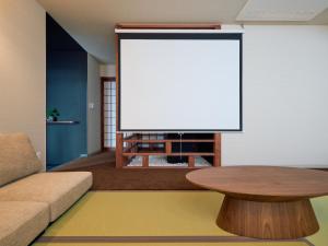 a living room with a table and a large screen at KONJAKUSO Osaka Tempozan KANOH SHOHAKU Sakura Pine Tree in Osaka
