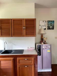 una cucina con un frigorifero viola e mobili in legno di Pool Dara Resort a Hua Hin