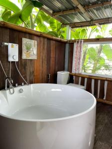 una vasca bianca in un bagno con alberi di Pool Dara Resort a Hua Hin