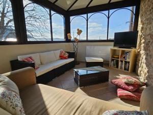 a living room with a couch and a tv at Au contact de la nature in Chatuzange-le-Goubet
