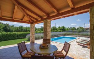 a patio with a table and chairs and a pool at Holiday Home Kunj Croatia in Kunj