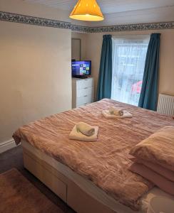 a bedroom with a large bed with towels on it at 2 Bedroom Family Cottage Dog Friendly Edern North Wales in Ederyn