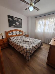 a bedroom with a bed and a ceiling fan at Apartamento Pilar solo familias in Gandía +31 photos