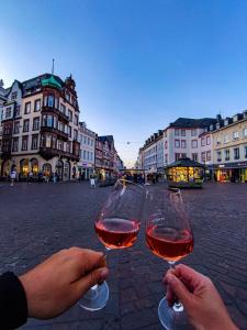 Due persone che portano bicchieri di vino in una strada cittadina di Ferienwohnung Moselnest a Longuich