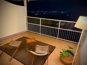 3 sillas y una mesa en un balcón con vistas en 日初山莊 Sunrise Taitung, en Fu-yüan