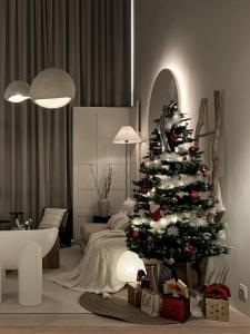 a christmas tree in a living room with a couch at Cozy Ins Duplex EkoCheras 1-6pax in Kuala Lumpur