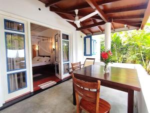 a dining room with a table and a bedroom at White Villa - Homestay in Tangalle