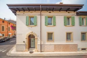 a building with green shutters on a street at Lady Capulet Apartments in Verona