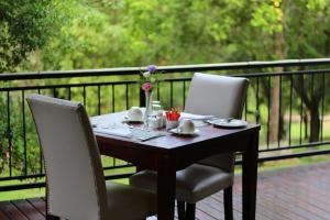 a wooden table with two chairs and a tableasteryasteryasteryasteryasteryasteryastery at La Villa Spa in Nelspruit