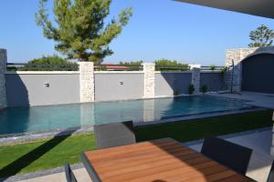 una piscina en un patio con una mesa de madera en Villam çeşme, en Cesme
