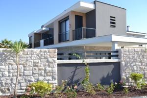 una casa moderna con un muro de piedra en Villam çeşme, en Cesme