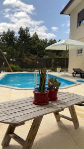 a wooden table with two potted plants on it next to a pool at Maison Miranda nord Portugal in Represas