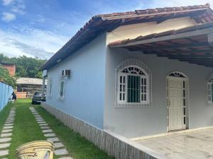 a blue and white house with a yard at casa de praia pontal do Piraquiaçu in Aracruz