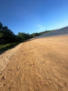 a dirt road next to a body of water at casa de praia pontal do Piraquiaçu in Aracruz