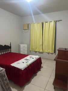 a bedroom with a bed and a yellow curtain at casa de praia pontal do Piraquiaçu in Aracruz