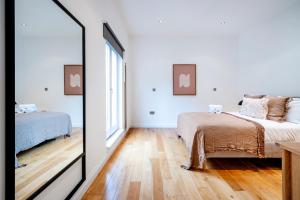 a bedroom with two beds and a mirror at 2 Bedr, 3 Beds, 2 Bath Covent Garden 3-min subway in London