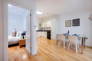 a kitchen and dining room with a table and chairs at 2 Bedr, 3 Beds, 2 Bath Covent Garden 3-min subway in London +11 photos