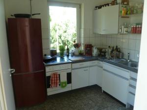a kitchen with white cabinets and a sink and a refrigerator at semi detached rural house in Dahlem