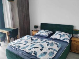 a bedroom with a bed with a green headboard and pillows at Widokowy Zakątek in Czorsztyn