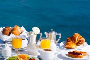 a table with a breakfast of croissants and orange juice at Hotel Casa Celestino in Sant'Angelo D'Ischia
