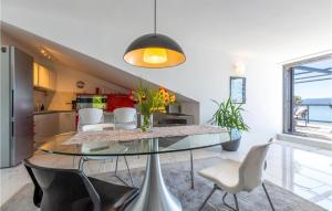 a dining room with a glass table and white chairs at Apartment Krilo Jesenice 24 in Jesenice
