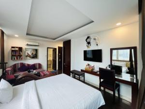 a bedroom with a bed and a desk with a computer at A25 Hotel - 20 Bùi Thị Xuân in Ho Chi Minh City
