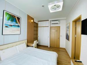 a bedroom with a white bed and a tv at Luxury Apartment Asiana Capella Trung tâm Chợ lớn in Ho Chi Minh City