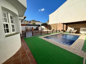 dom z basenem z zieloną trawą w obiekcie Villa Casa Vega Fuengirola w mieście Fuengirola