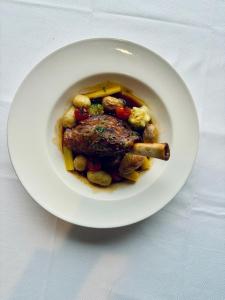 a plate of food with meat and vegetables on a table at La Cremaillere Hôtel-Restaurant in Courseulles-sur-Mer