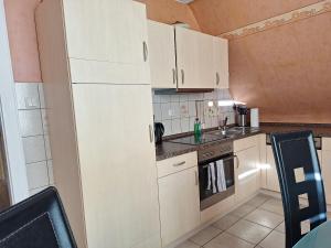 a small kitchen with white cabinets and a sink at Villa Duli in Bad Harzburg