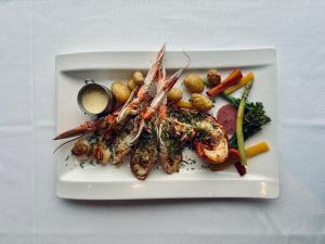 a plate of food with seafood and vegetables on a table at La Cremaillere Hôtel-Restaurant in Courseulles-sur-Mer