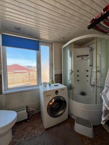 a bathroom with a washing machine and a sink at SARAN Guest House in Gachuurt