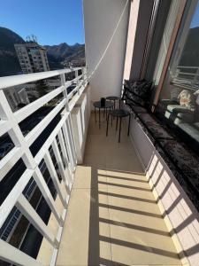 Un balcón con sillas y mesas en un edificio. en Апартамент Слънчев дом, en Smolyan
