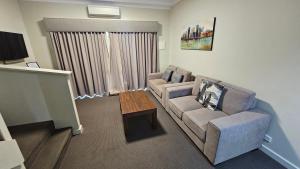 a living room with a couch and a coffee table at Bunbury Stay at Sanctuary Resort Strata in Bunbury