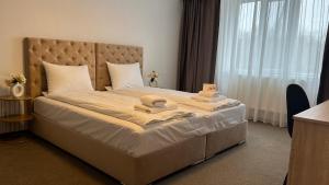 a bedroom with a large bed with towels on it at Europa Ocna Mures in Ocna-Mureşului