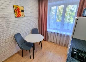 a room with a table and two chairs and a window at Янко 79 in Kokshetau