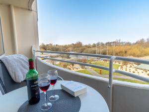 a table with two glasses and a bottle of wine at Strandnahe Fewo inkl Pool, Whirlpool, Sauna & Strandkorb 234 in Cuxhaven