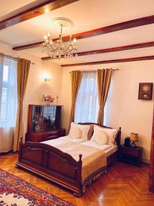 a bedroom with a bed and a chandelier at Joseph Hayn Apartments in Sighişoara