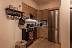 ユッラスヤルヴィにあるDuetto by Hi Ylläsのステンレス製の冷蔵庫とコンロを備えたキッチン