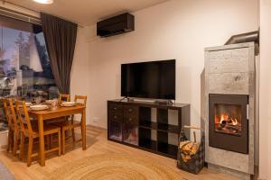 ユッラスヤルヴィにあるDuetto by Hi Ylläsのテーブルと暖炉のあるリビングルーム