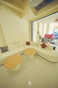 a living room with a white couch and two tables at Wonderful inn 2 in Pattaya Central